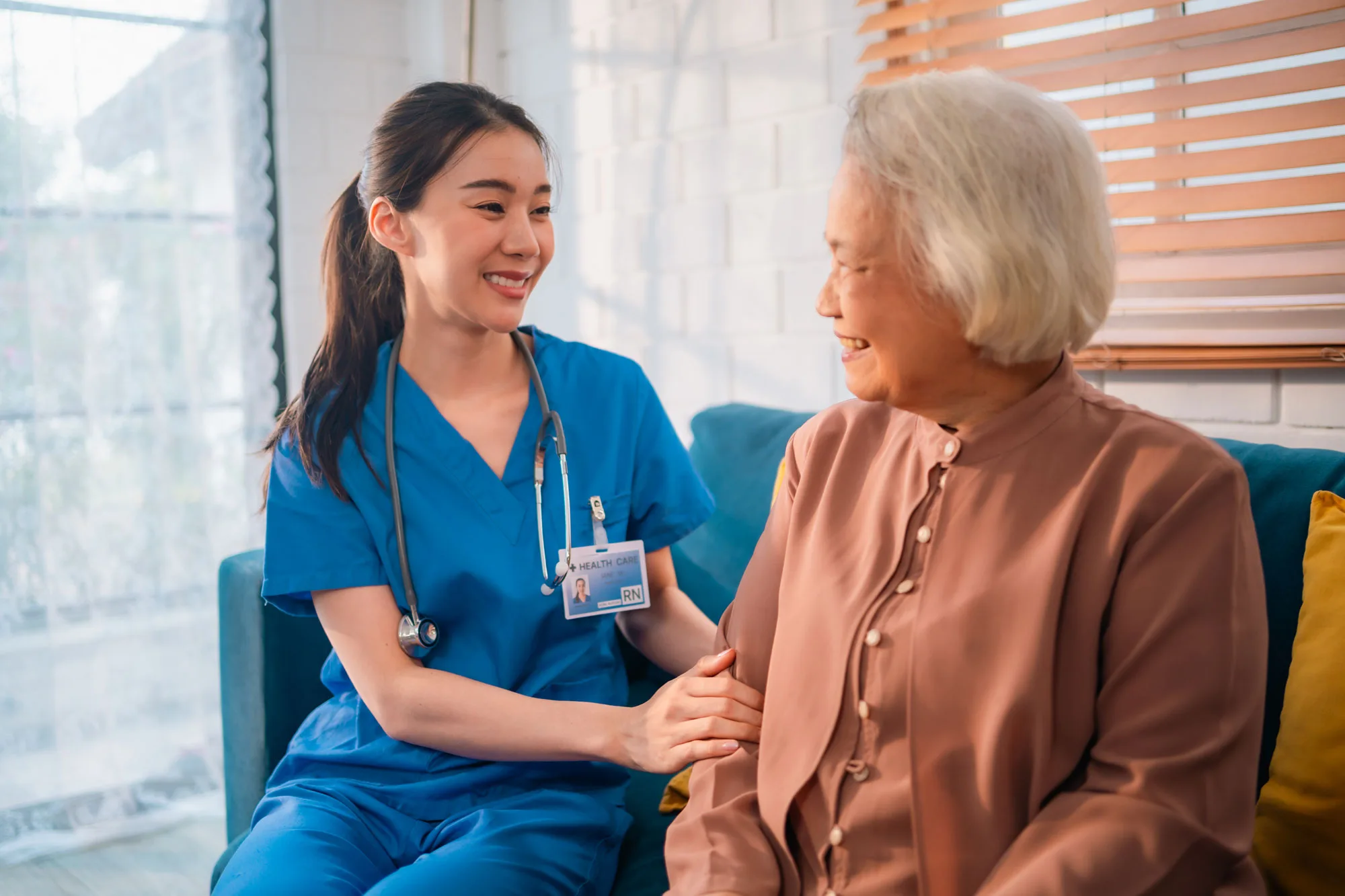Caregiver sitting with a senior woman while discussing personalized wellness and in-home healthcare support in Newark, NJ